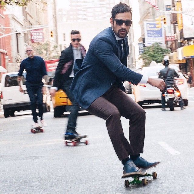 Men skateboarding in formal wear on the street