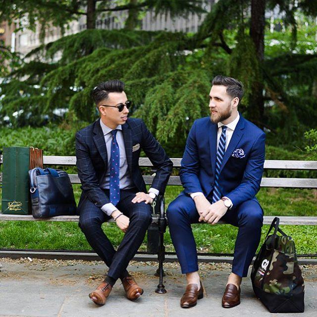 Two men sitting on a bench in formal wear